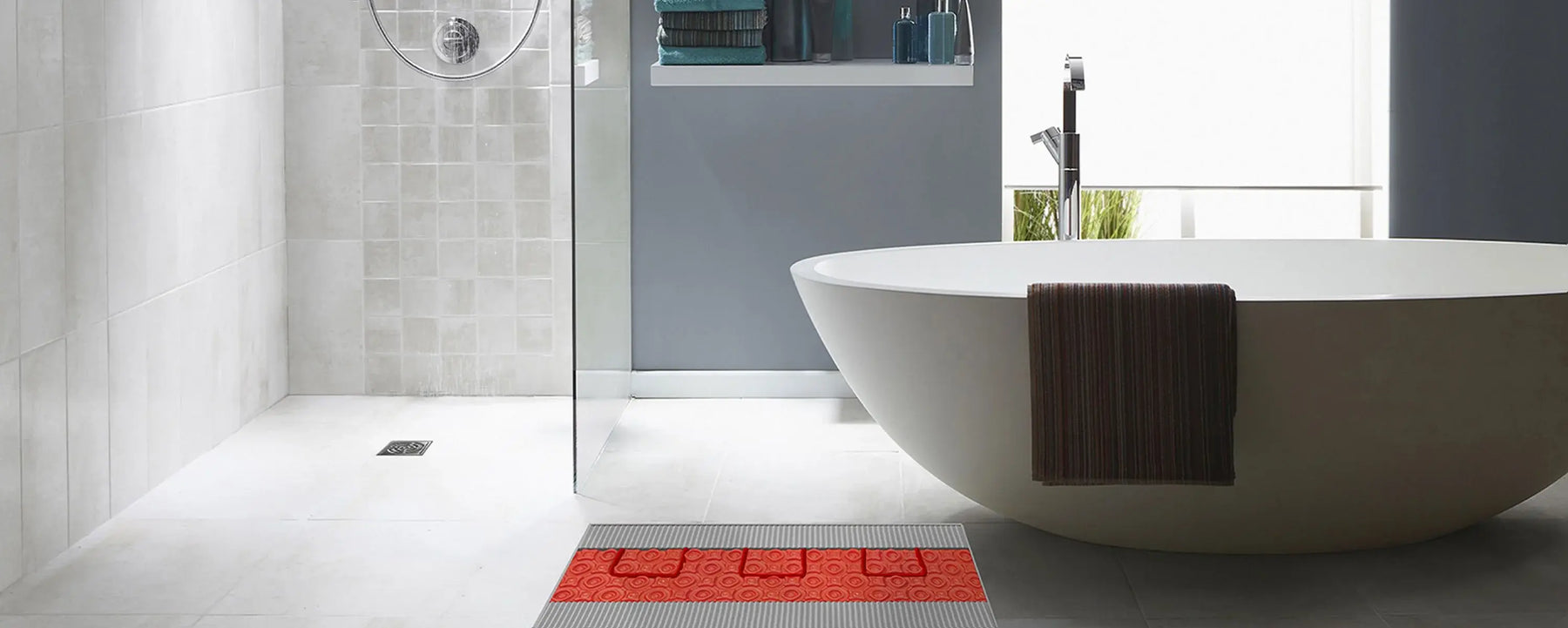 Underfloor heating membrane beneath large bathroom tiles for even warmth in a spa inspired space.