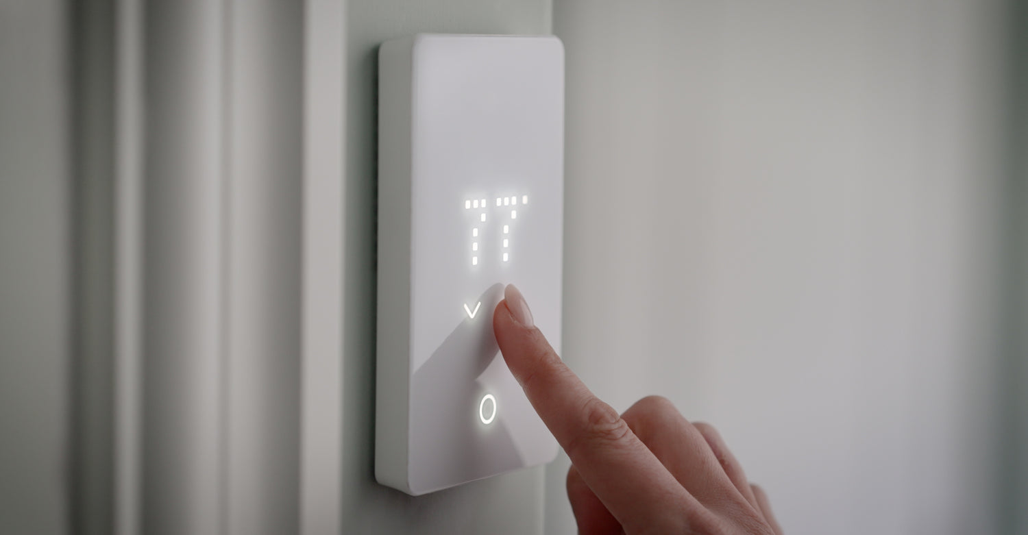 woman adjusting temperature on floor heating thermostat